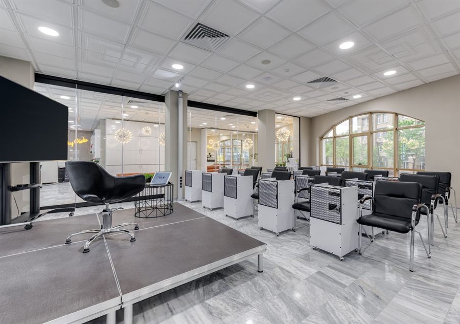 Bright conference room with a low stage and rows of chairs