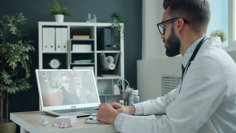 Doctor on a video call at a laptop in a clinic office