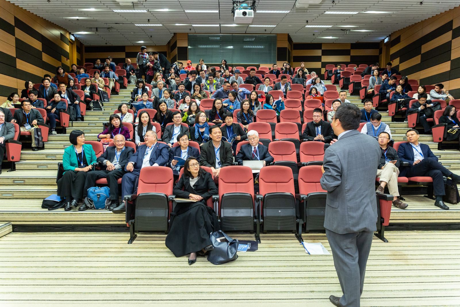 Speaker addressing a full auditorium, the role of a cruise ship lecturer