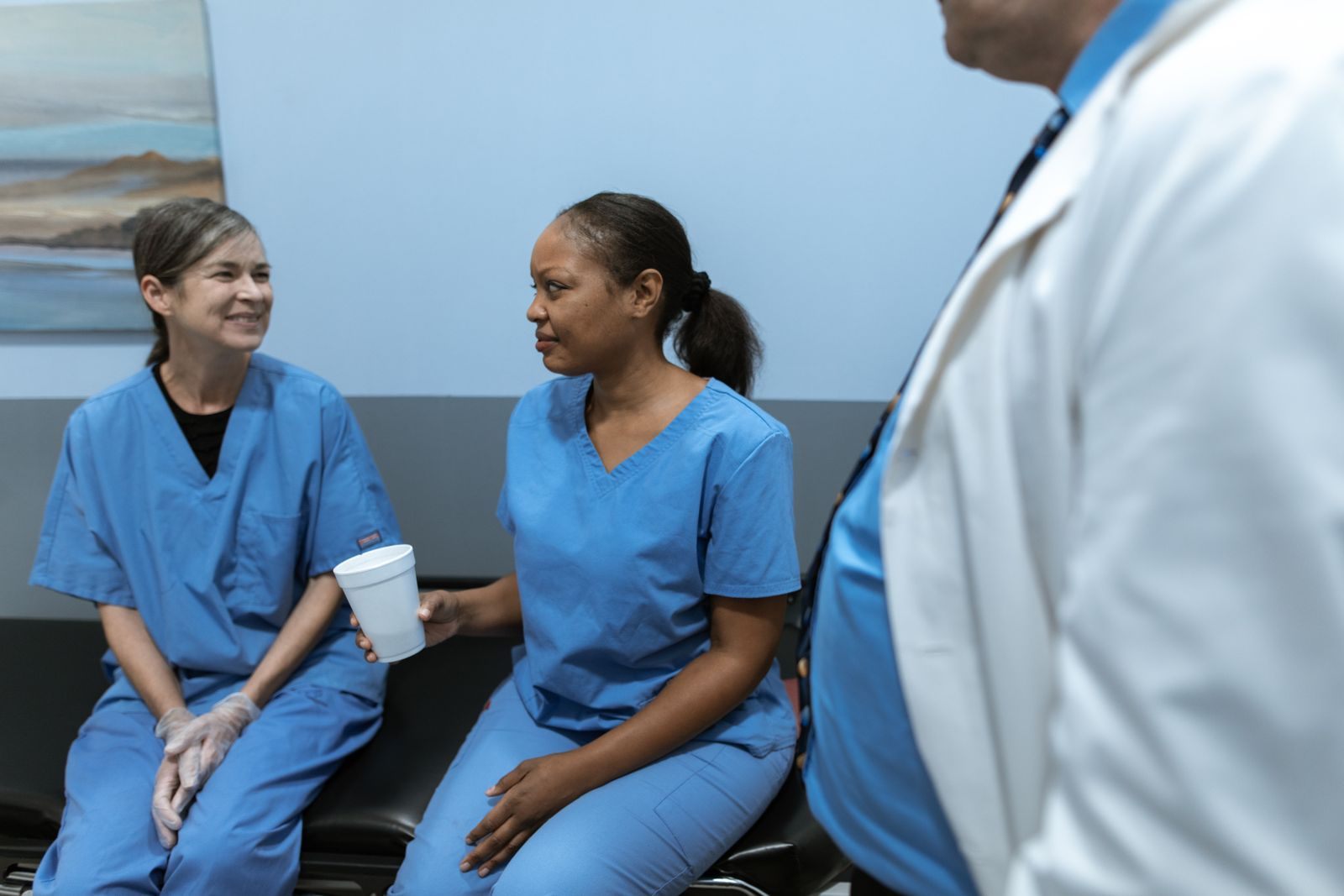 Nurses in scrubs talking during a break, colleagues who might choose nursing CE cruises